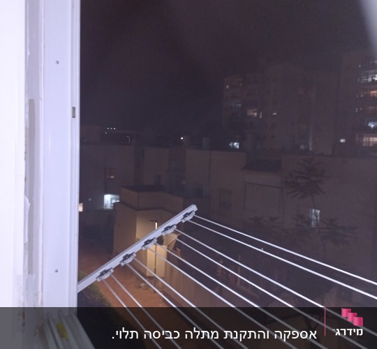 חבלי כביסה מחוברים לחלון פתוח בלילה